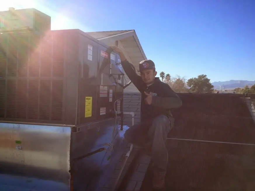 HVAC technician performing AC Tune-Up on a rooftop unit in Mulvane